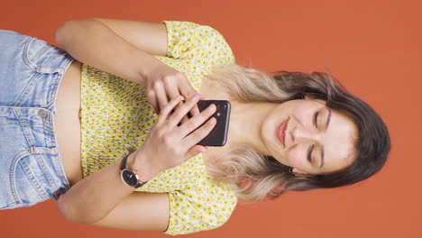 Vertical-video-of-The-young-woman-who-happily-puts-the-phone-to-her-heart.